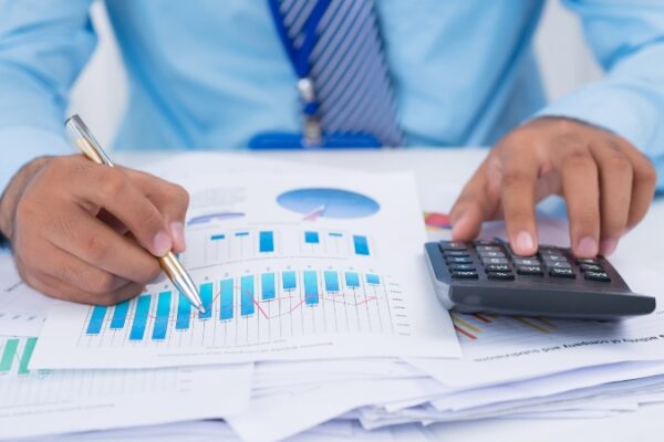 Preduzetnik analizira finansijske izveštaje uz kalkulator i grafikone na stolu