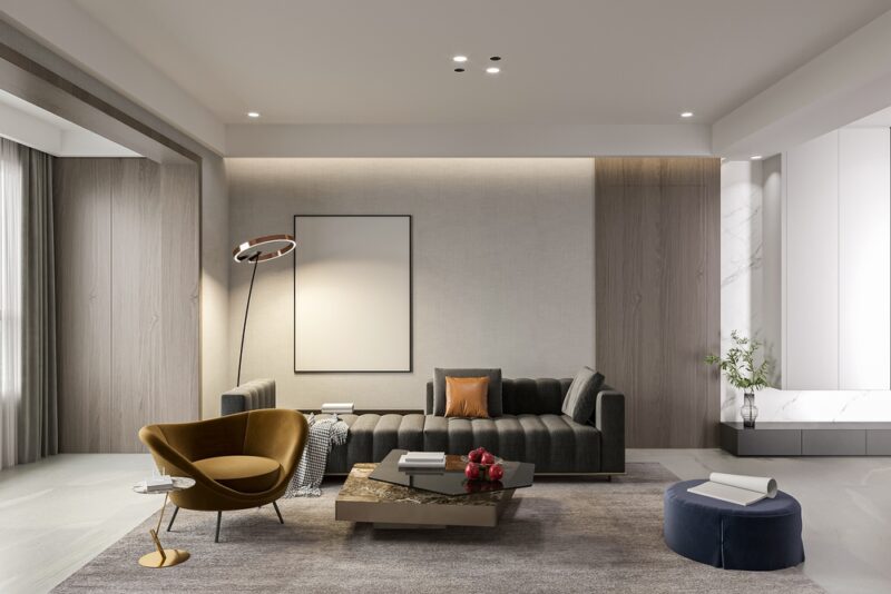 Savremen dnevni boravak sa tamnom sofom, foteljom i niskim stočićem u neutralnim tonovima