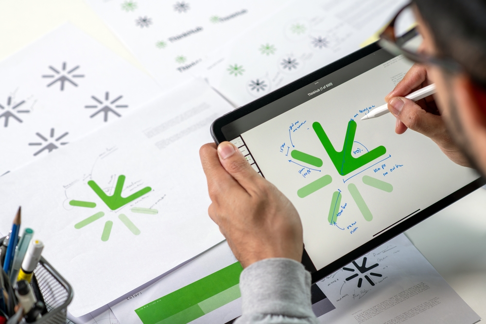 Dizajner razvija vizuelni identitet brenda kroz skice i digitalne elemente