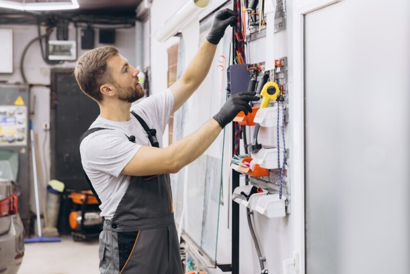 Majstor u radionici koristi zidni sistem sa kutijama za organizaciju sitnog alata