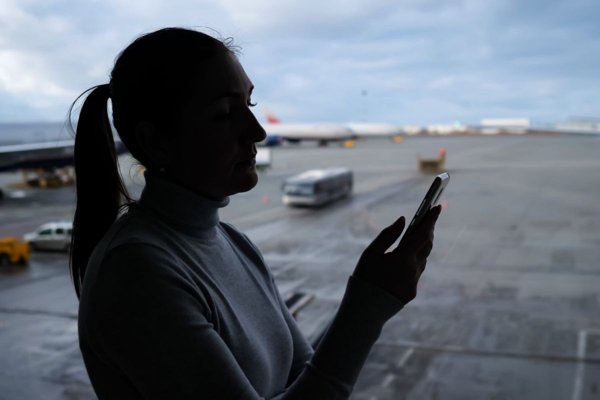 devojka koristi telefon na aerodromu