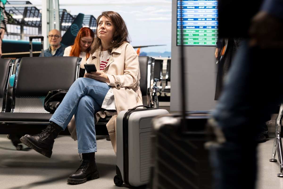 devojka čeka prevoz na aerodromu